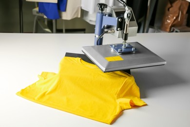 Printing logo. Heat press with yellow t-shirt on white table, space for text