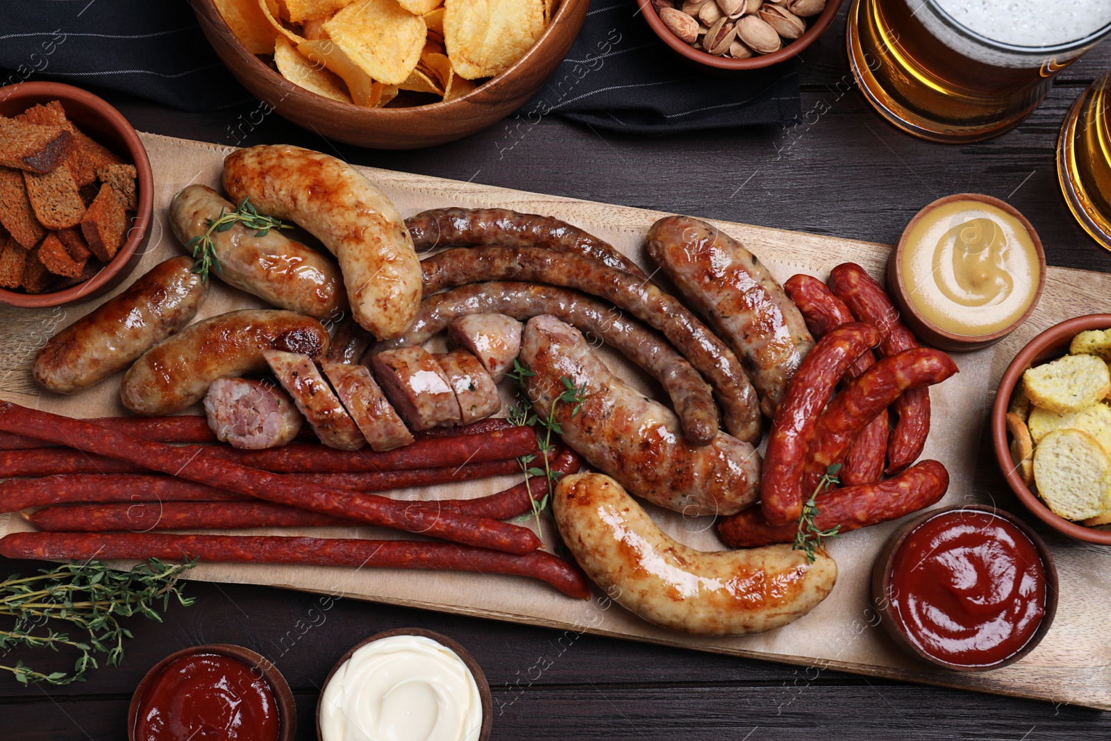 Photo of Set of different tasty snacks and beer on wooden table, flat lay