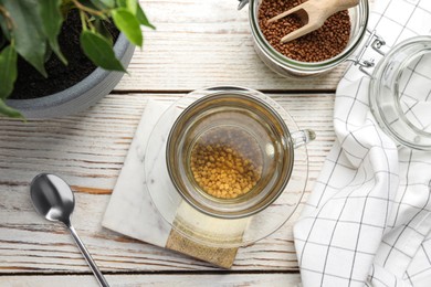 Photo of Freshly made buckwheat tea on white wooden table, flat lay