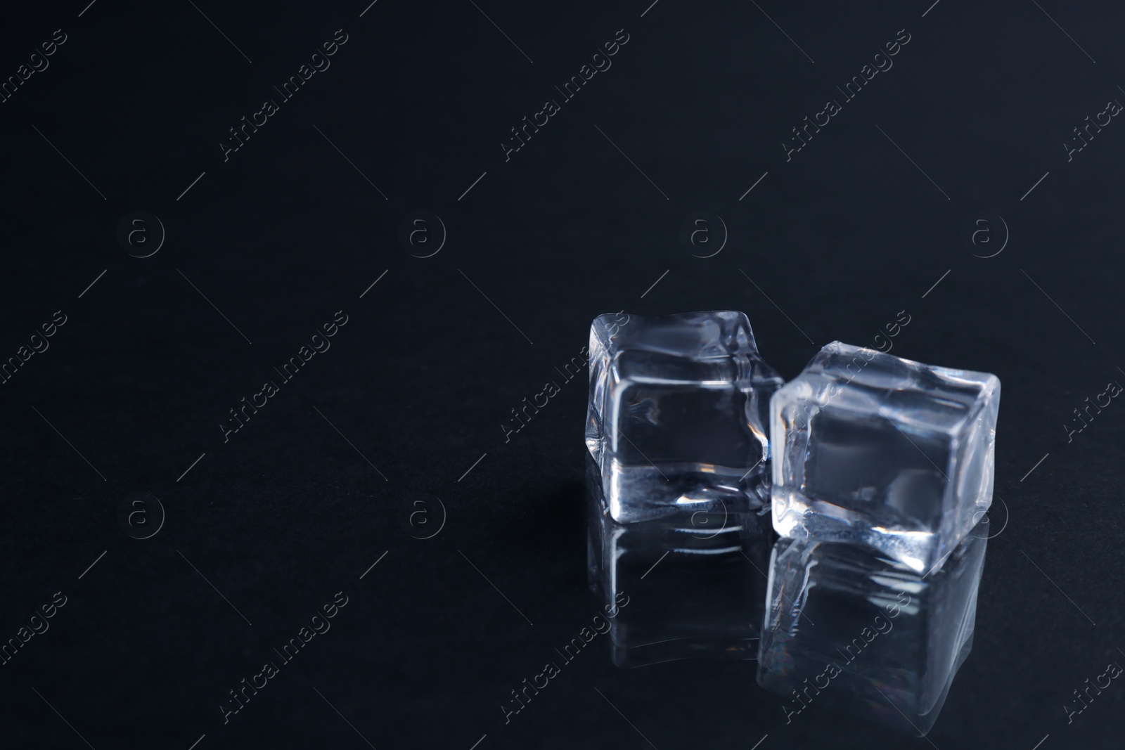 Photo of Crystal clear ice cubes on black background. Space for text