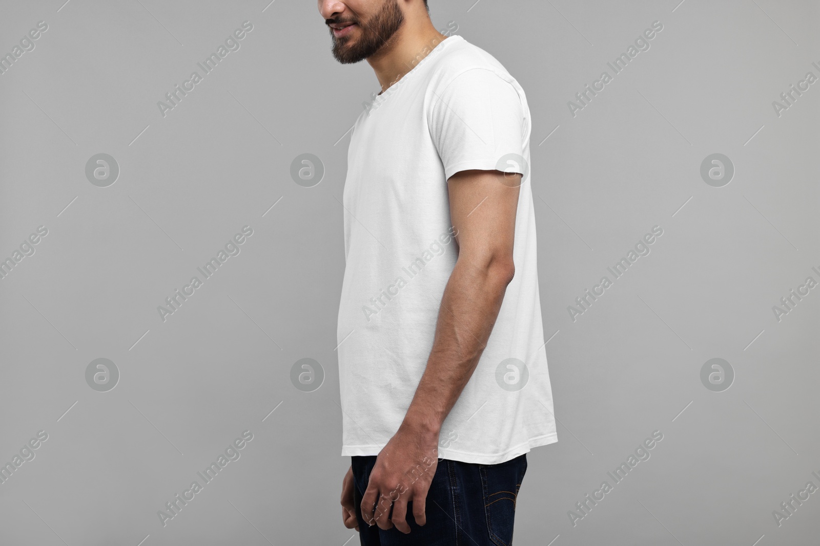 Photo of Man in white t-shirt on grey background, closeup