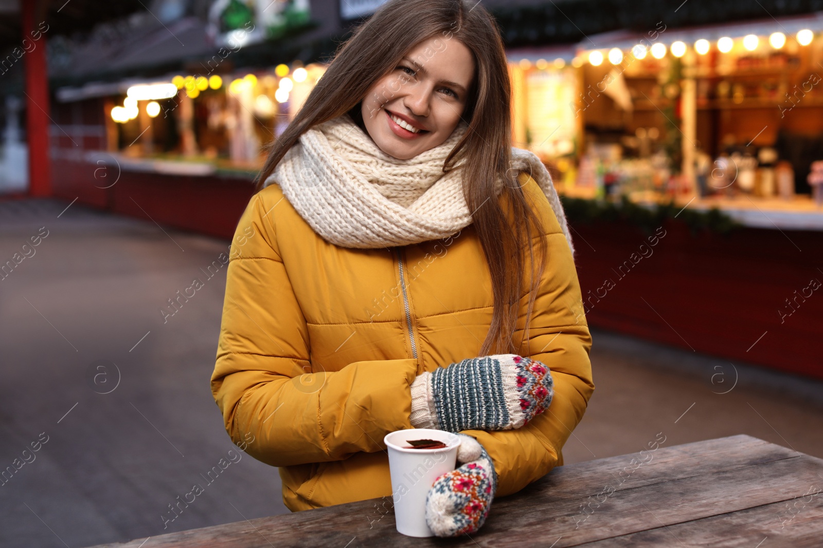 Photo of Happy woman with mulled wine at winter fair