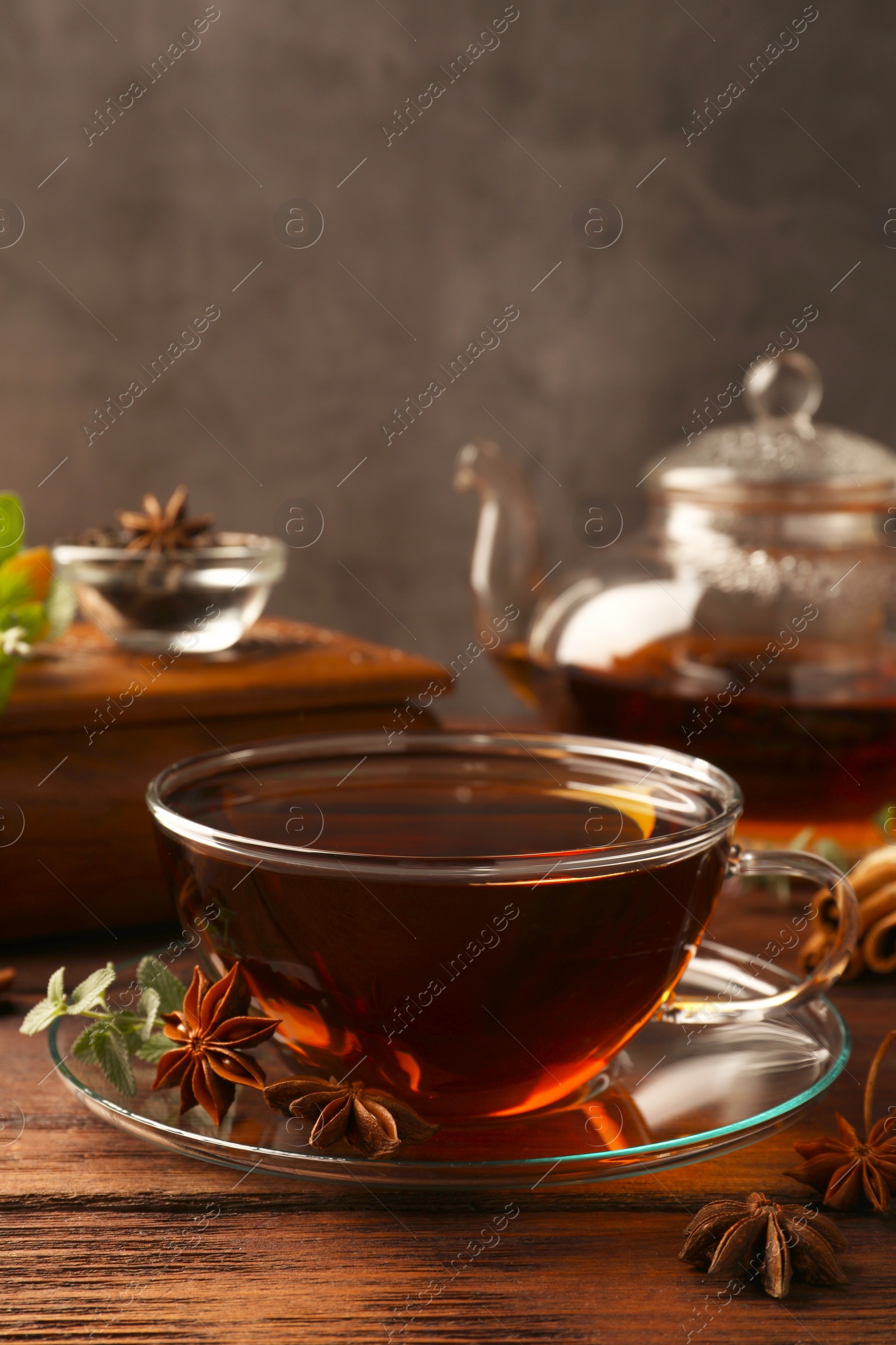 Photo of Aromatic tea with anise stars and mint on wooden table