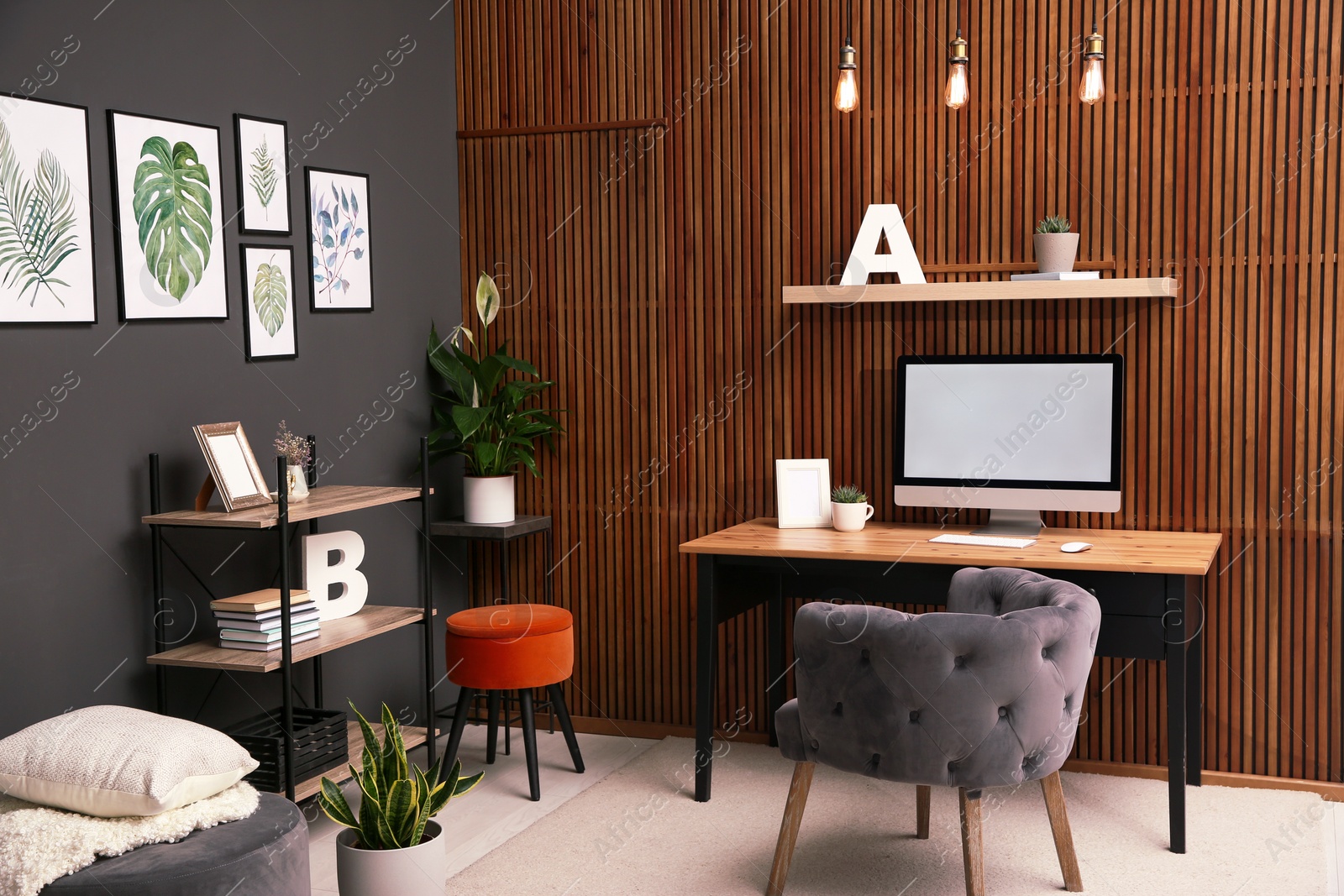 Photo of Comfortable workplace with computer near wooden wall in stylish room interior. Home office design