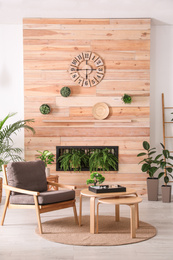 Photo of Stylish living room interior with armchair, green plants and miniature zen garden. Home design ideas