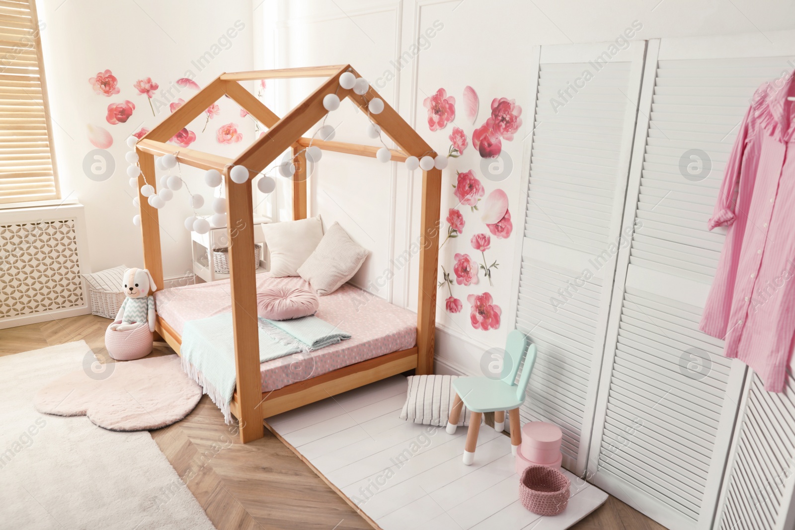 Photo of Stylish child room interior with wooden house bed