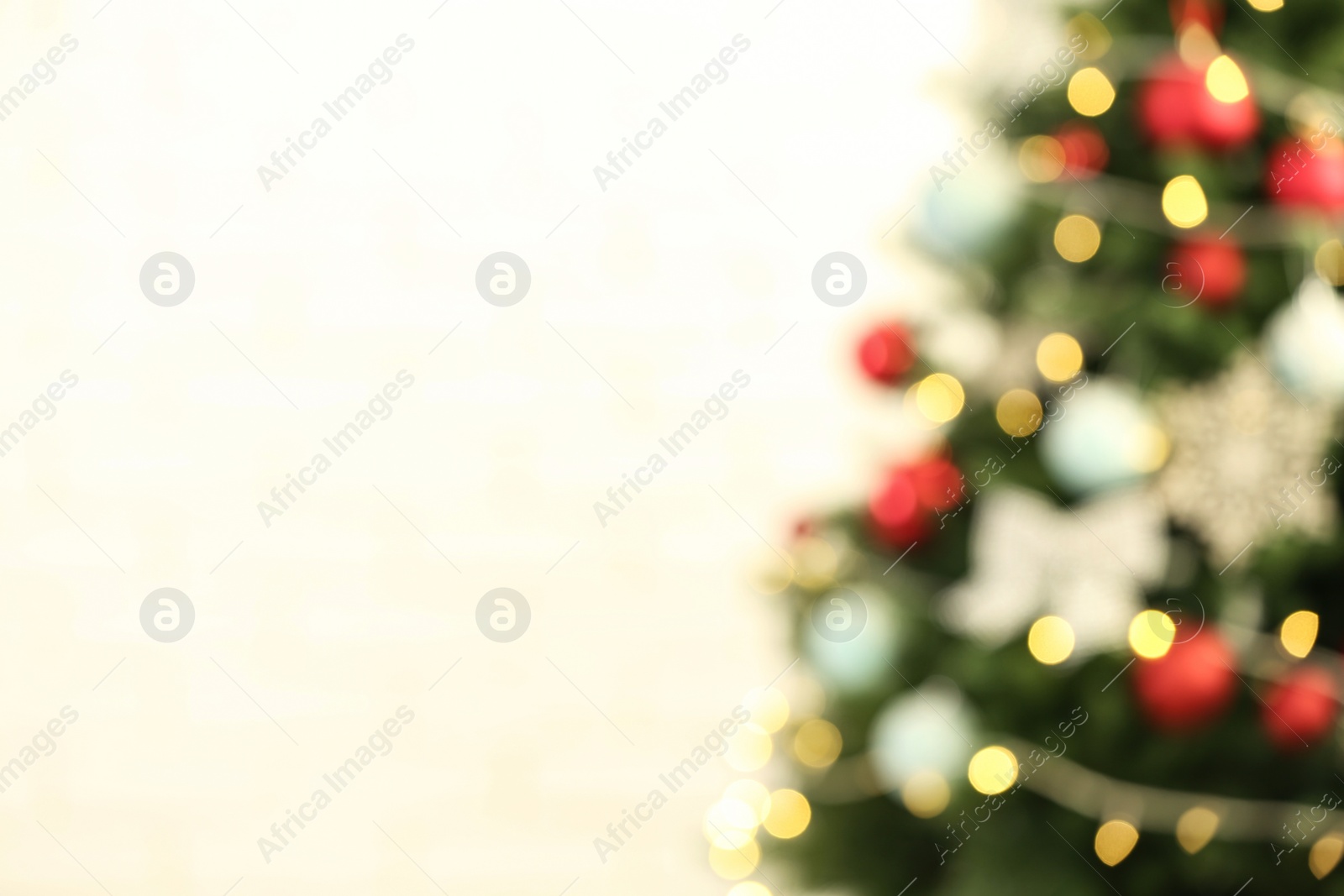 Photo of Beautiful Christmas tree with lights against yellow background, blurred view. Space for text