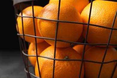 Photo of Basket with ripe oranges on dark background, closeup