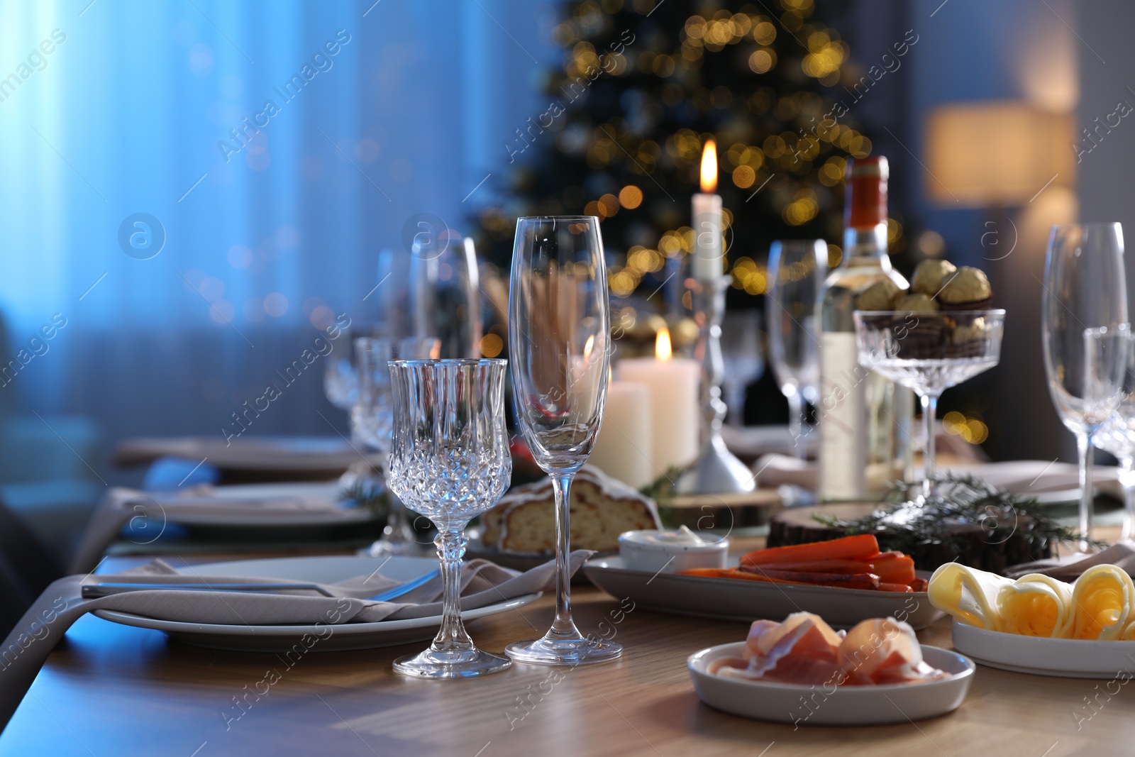 Photo of Christmas table setting with festive decor and dishware indoors