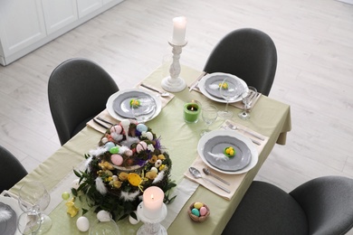 Photo of Beautiful Easter table setting with burning candles indoors, above view