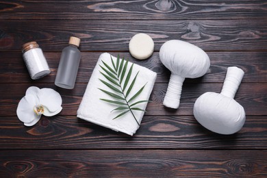 Photo of Flat lay composition of herbal bags and spa products on wooden table