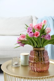 Photo of Beautiful bouquet of colorful tulip flowers on coffee table in room