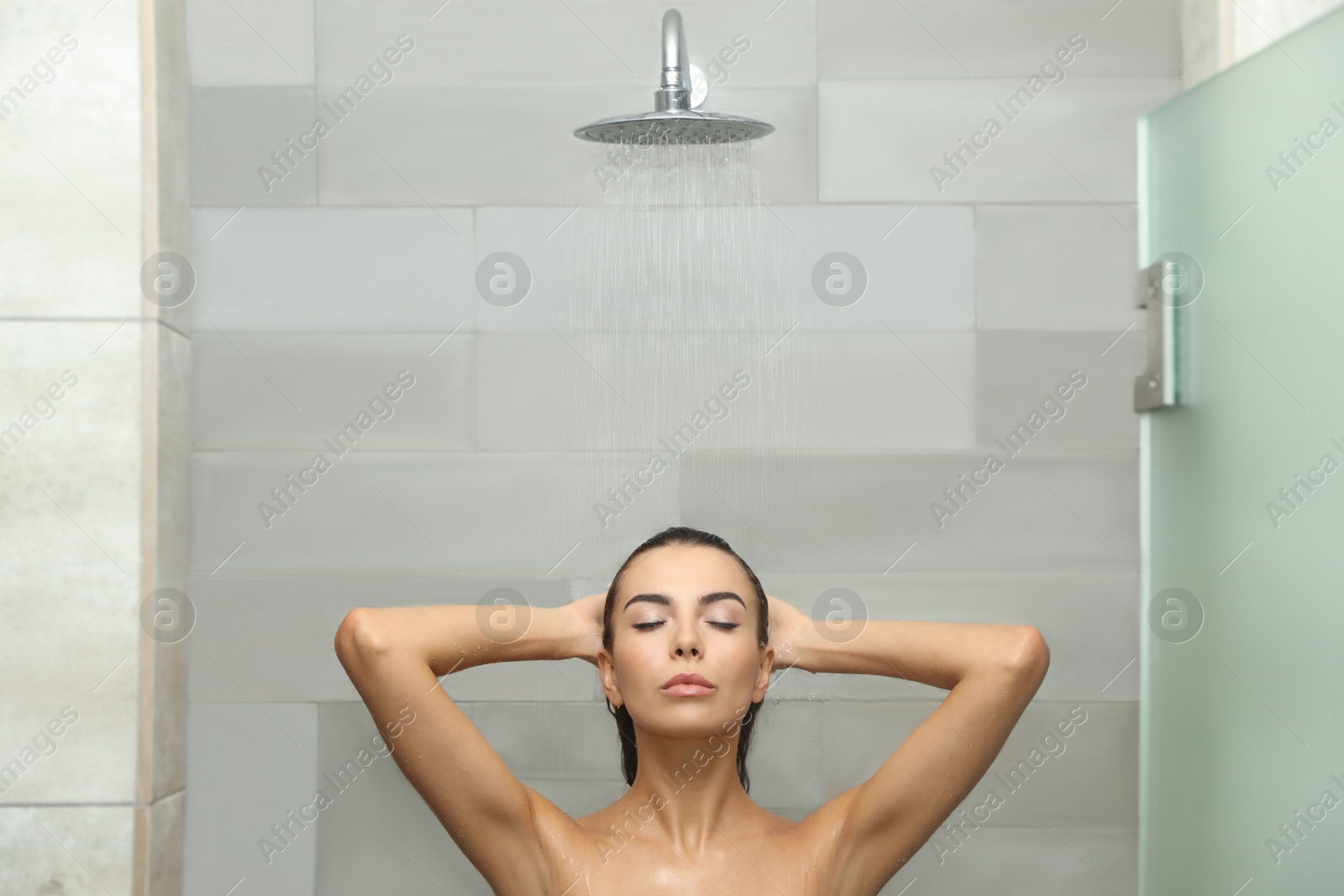 Photo of Beautiful young woman taking shower in spa center