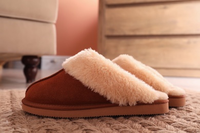 Photo of Brown warm slippers on floor in room