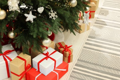 Beautiful Christmas tree and gift boxes in stylish room. Interior design