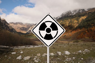 Image of Radioactive pollution. Warning sign with hazard symbol in mountains