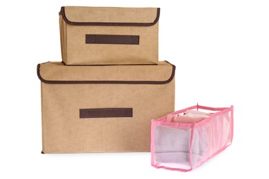Photo of Textile storage cases and organizer with clothes on white background