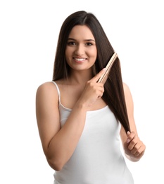 Beautiful young woman with hair comb on white background