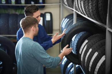 Photo of Service center consultant helping customer to choose tire in store