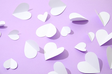 Small paper hearts on color background