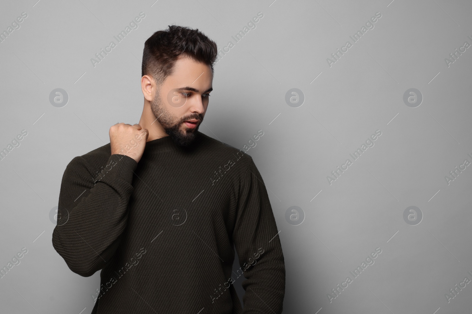 Photo of Handsome man in stylish sweater on grey background, space for text