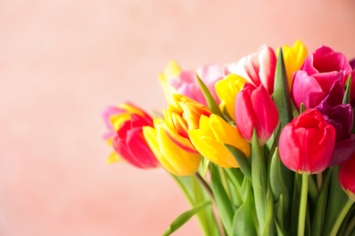 Photo of Beautiful spring tulips on light pink background, closeup. Space for text