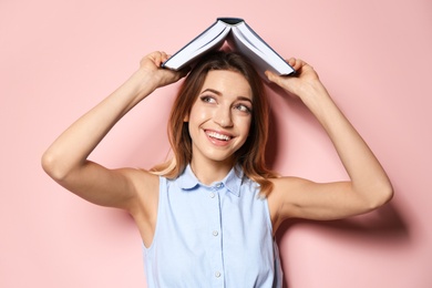 Photo of Young woman with book on color background