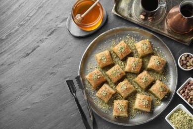 Photo of Delicious fresh baklava with chopped nuts served on grey table, flat lay and space for text. Eastern sweets