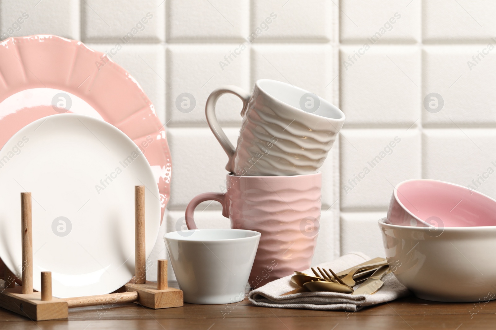 Photo of Beautiful ceramic dishware, cups and cutlery on wooden table