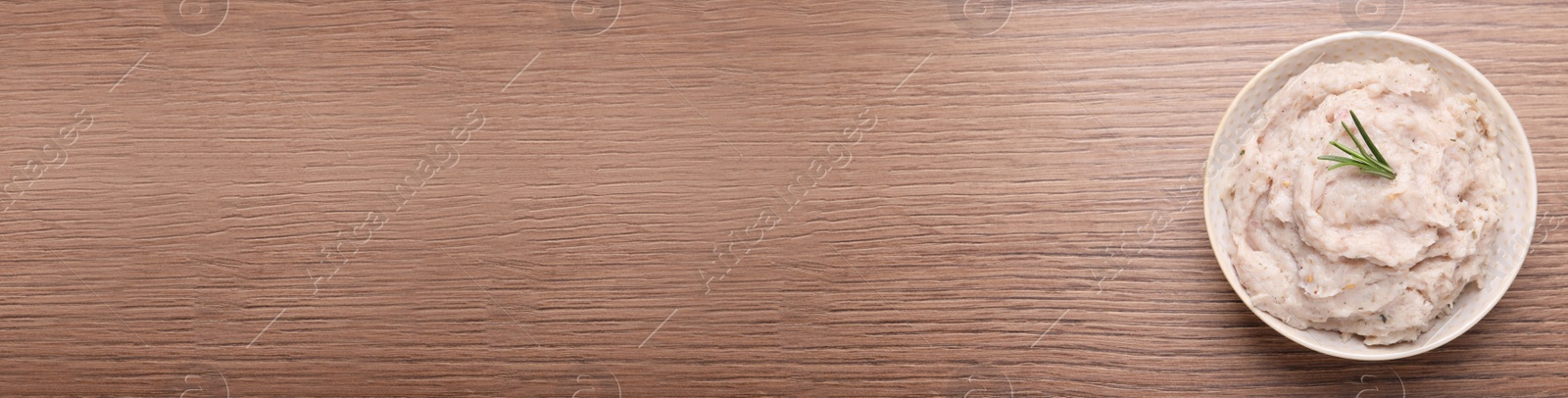 Photo of Delicious lard spread in bowl on wooden table, top view. Space for text