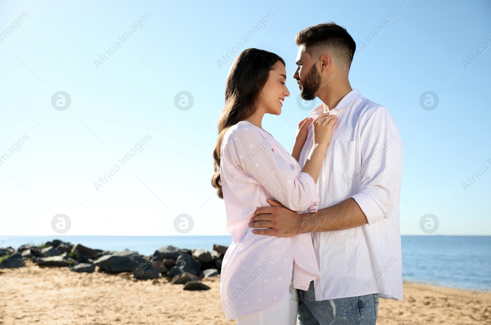 Photo of Happy young couple on beach near sea. Honeymoon trip