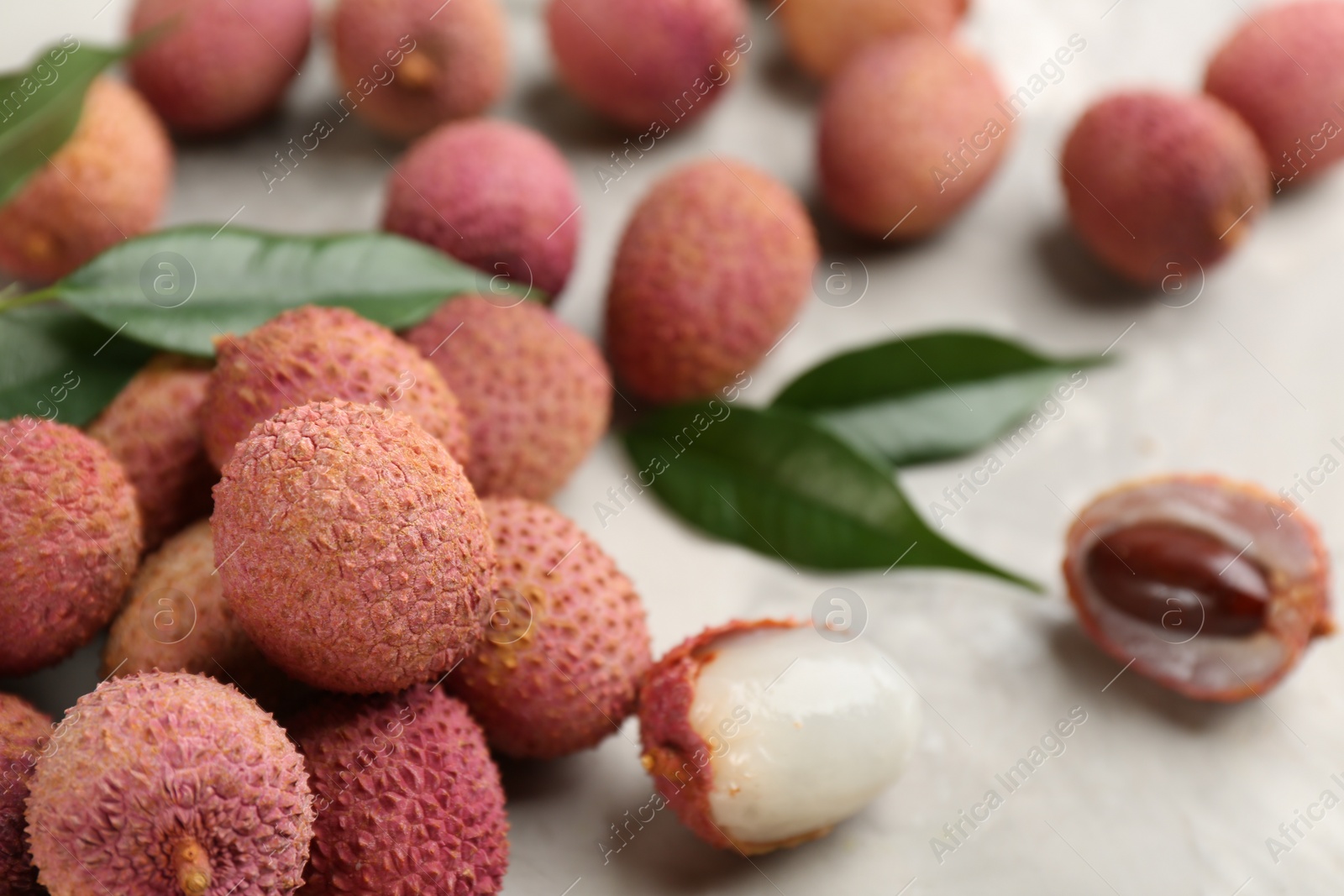 Photo of Fresh ripe lychee fruits on light grey table