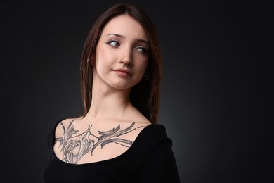 Portrait of beautiful tattooed woman on black background