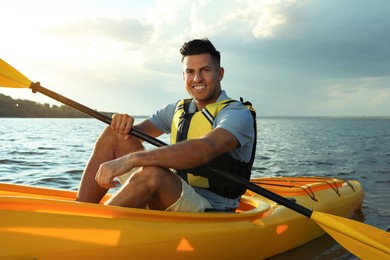 Happy man kayaking on river. Summer activity