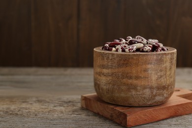 Bowl with dry kidney beans on old wooden table. Space for text