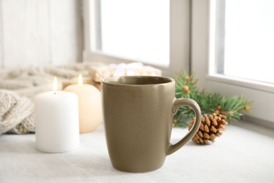 Composition with cup of hot winter drink near window. Cozy season