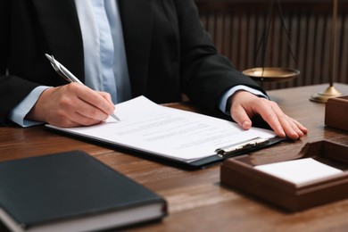 Photo of Lawyer working at wooden table indoors, closeup