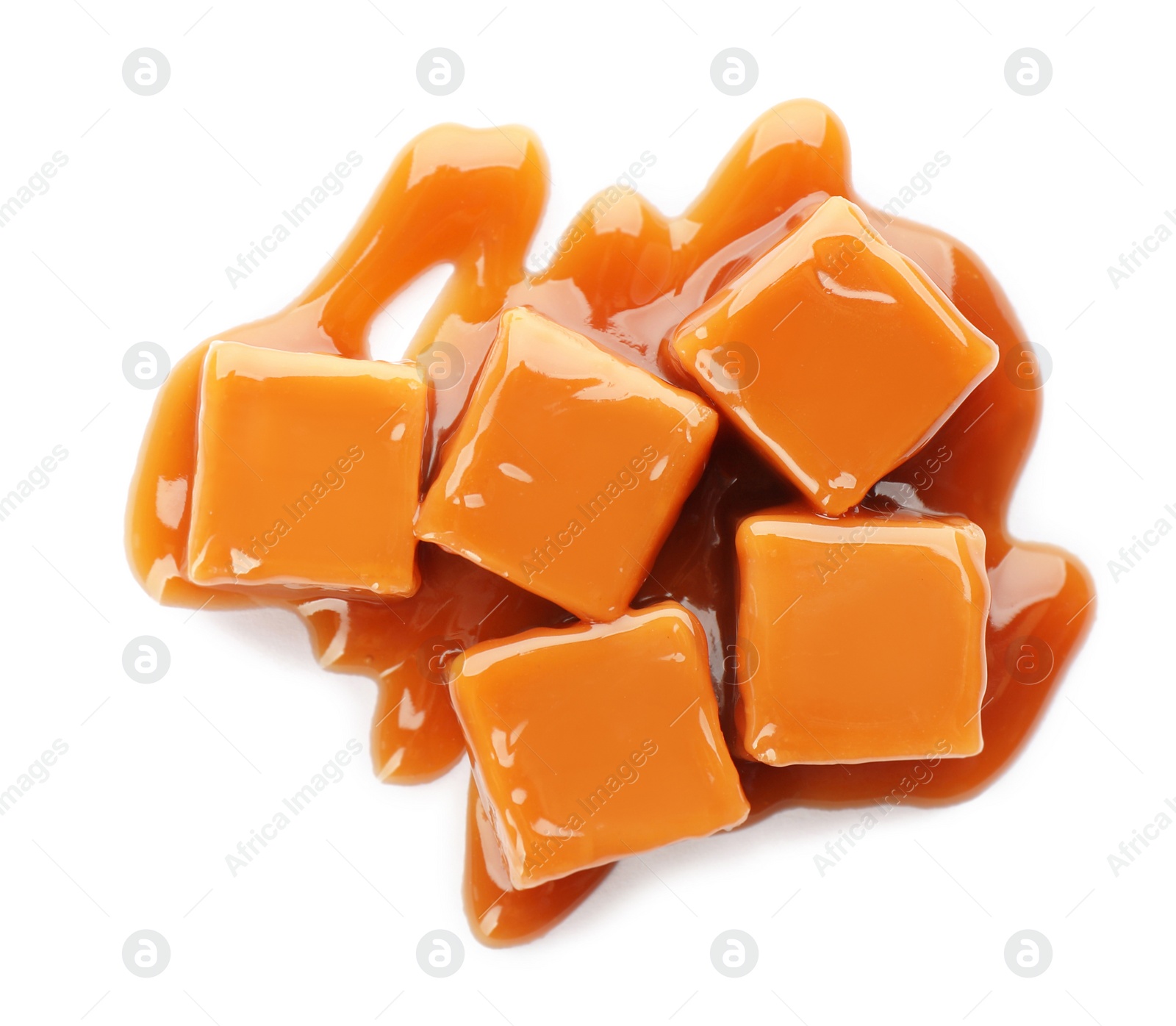 Photo of Heap of sweet caramel candies with topping isolated on white, top view