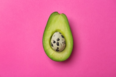 Composition with ripe avocado and quail egg on color background, top view