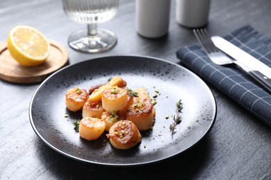 Photo of Delicious fried scallops served on dark gray textured table, closeup