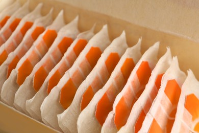 Photo of Many tea bags in box, closeup view