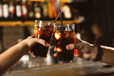 Photo of Young couple with glasses of cola in bar, closeup