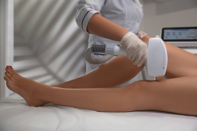 Photo of Woman undergoing laser epilation procedure in beauty salon, closeup