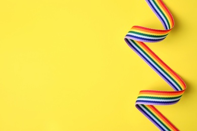 Bright rainbow ribbon on color background, top view with space for text. Symbol of gay community