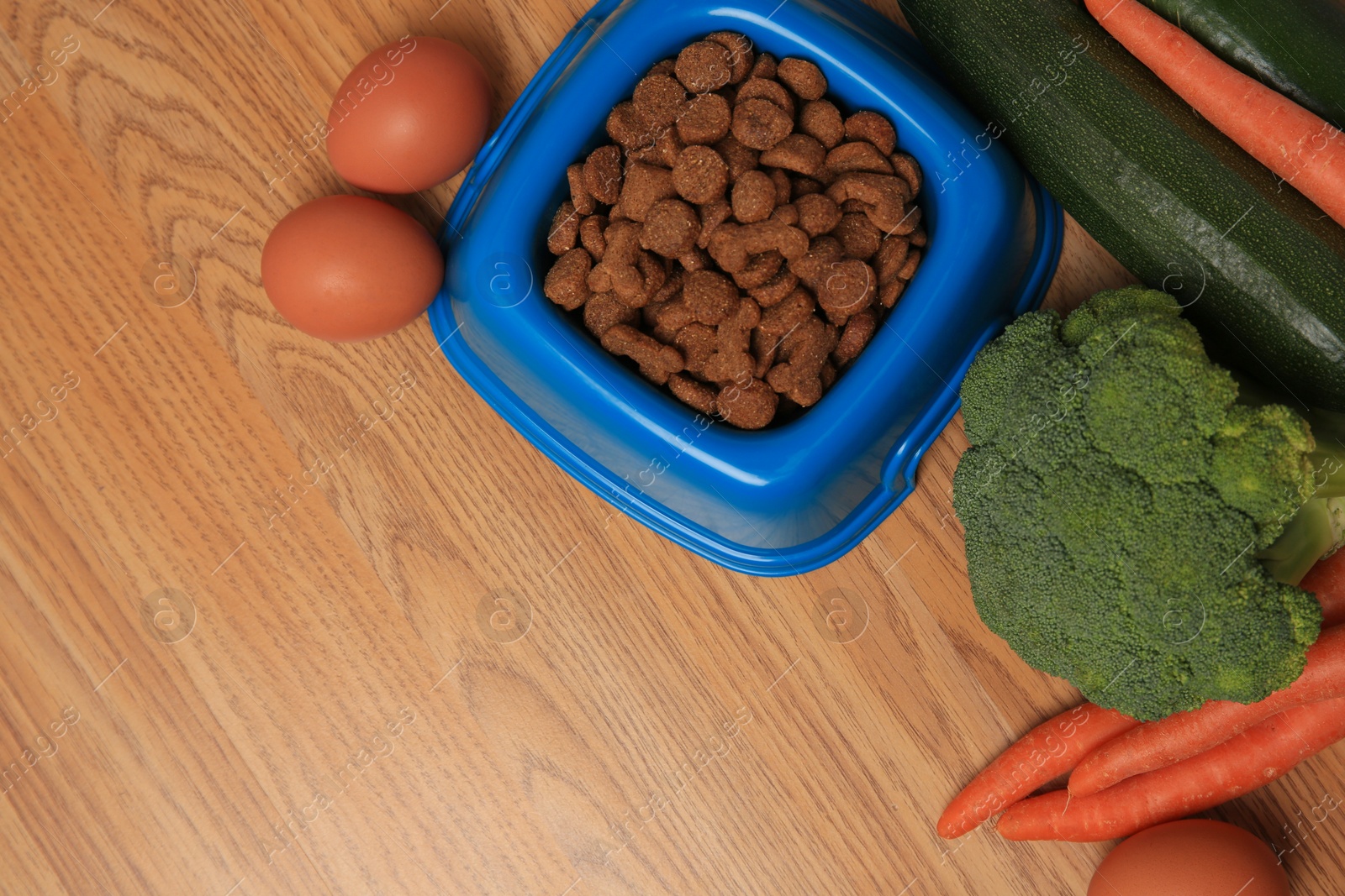 Photo of Dry pet food and products on wooden background, flat lay. Space for text