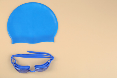 Photo of Swim goggles and cap on light background, flat lay. Space for text