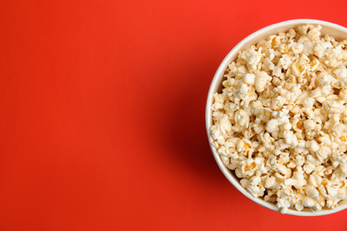 Tasty pop corn on red background, top view. Space for text