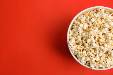 Photo of Tasty pop corn on red background, top view. Space for text