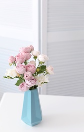 Photo of Vase with beautiful flowers on table indoors