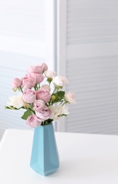 Vase with beautiful flowers on table indoors